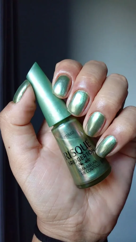 Esmalte verde metálico Risqué coleção Bridgerton aplicado nas unhas.