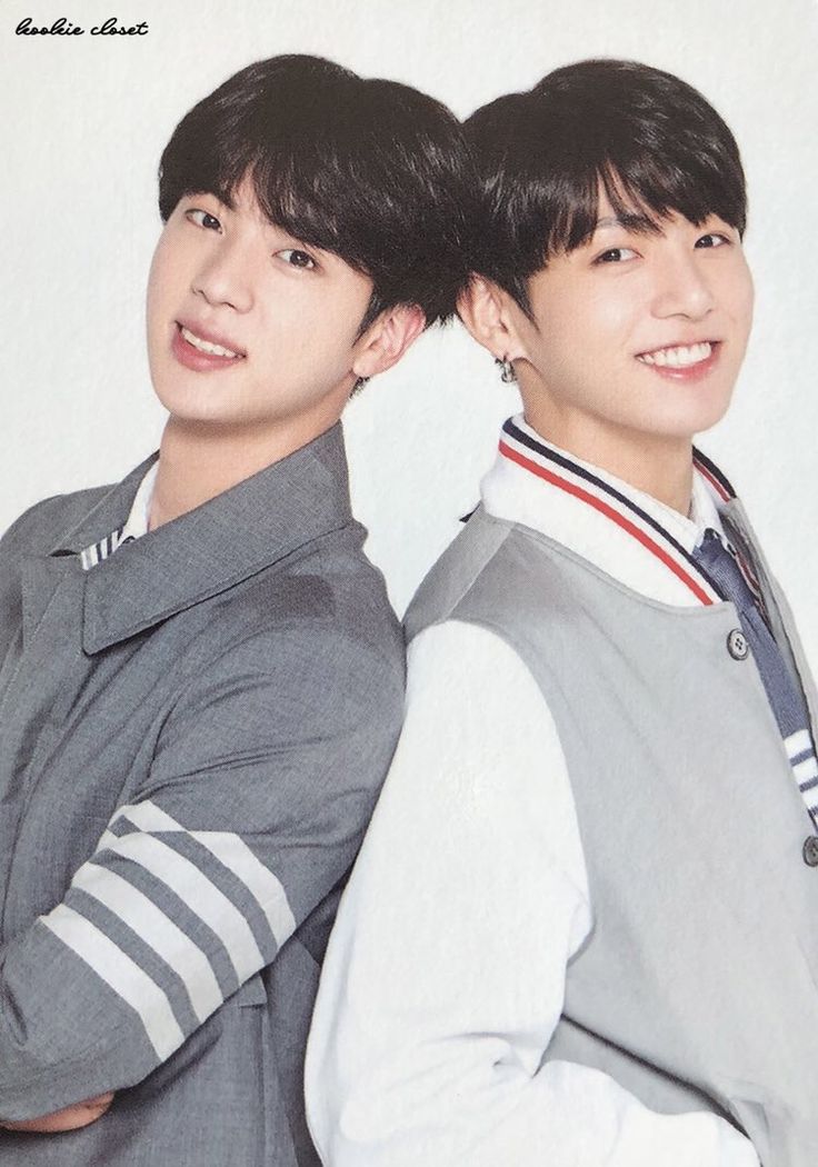 Jin e Jungkook do BTS em foto promocional, sorrindo e encostados de costas um no outro. Jin veste uma jaqueta cinza com listras brancas e Jungkook, uma jaqueta cinza e branca com listras vermelhas e azuis.