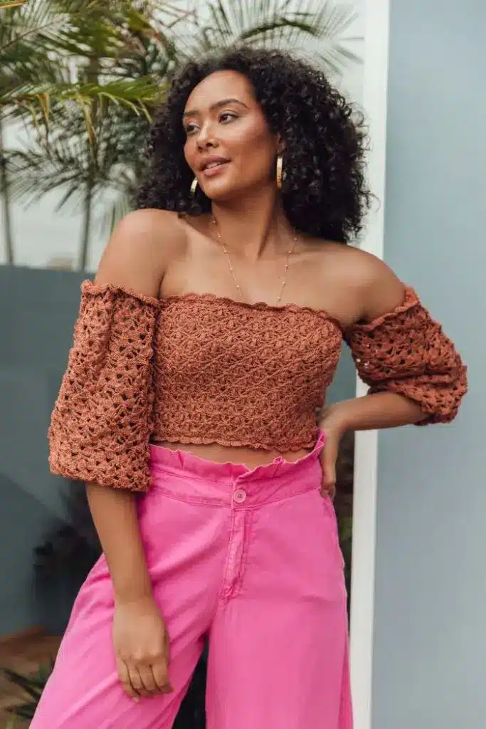 Mulher usando uma blusa ciganinha (ombro a ombro), estilo elegante e fresco.