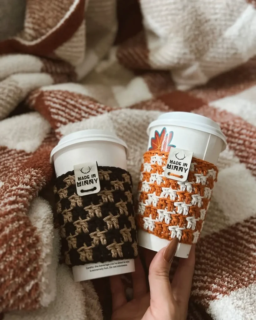 Capa de crochê para xícara de café com padrões em tons de marrom e laranja