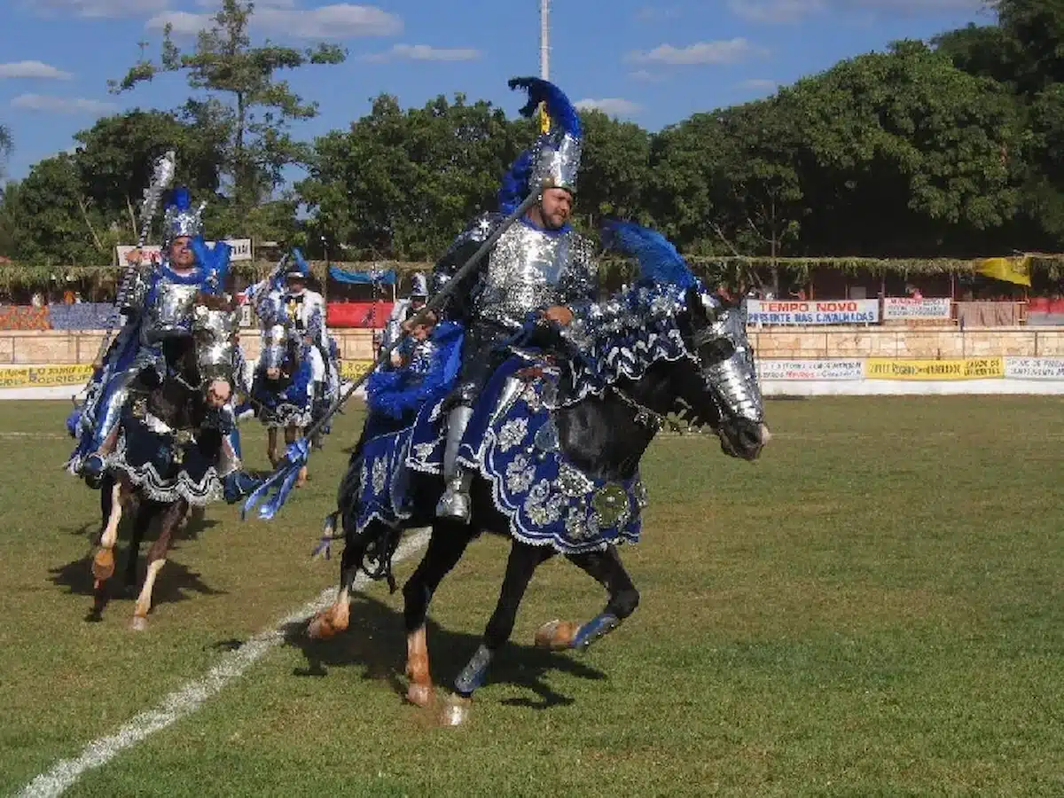 Cavalhada de Pirenópolis, com cavaleiros em armaduras coloridas e adornos brilhantes, em desfile durante a festa popular de Goiás.