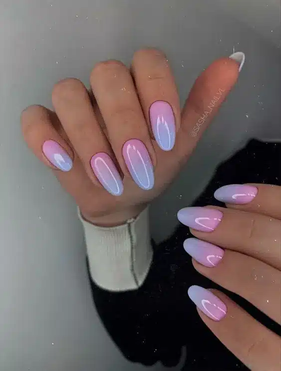 Unhas com efeito degradê em azul bebê e rosa claro, técnica de baby boomer