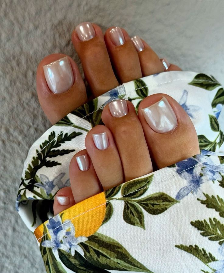 Unhas dos pés pintadas com esmalte perolado ou cromado, demonstrando um acabamento metálico brilhante que ajuda a alongar visualmente o formato das unhas.