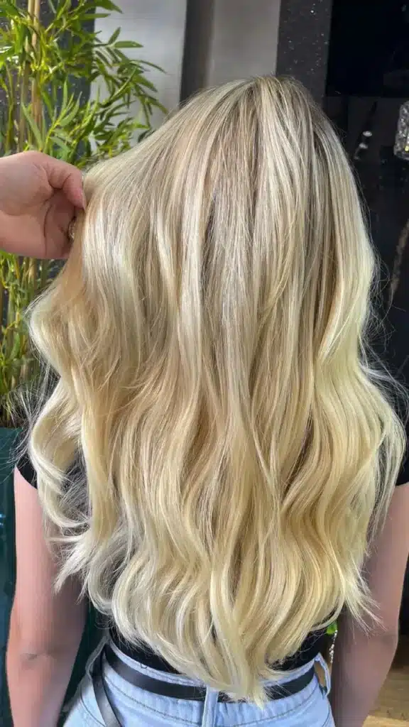 Cabelos loiros manteiga com ondas naturais, exalando brilho e suavidade.