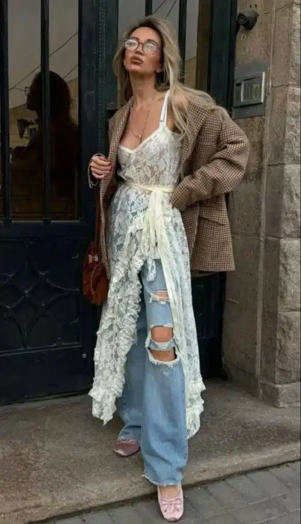 Vestido de renda e calça jeans: sobreposição criativa. Look criativo com vestido de renda sobre calça jeans rasgada e sapatos rosados.