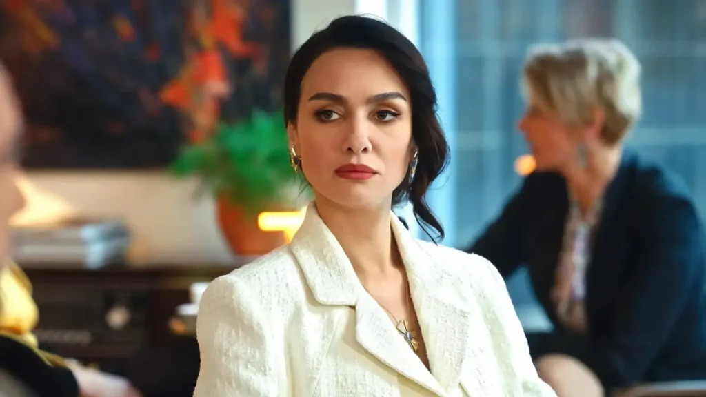 Mulher elegante com expressão séria em uma reunião, representando personagem de Asas da Ambição.