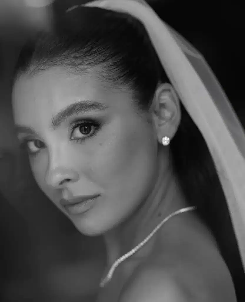 Close-up de mulher com brinco solitário de diamante, mostrando a delicadeza e brilho da joia.