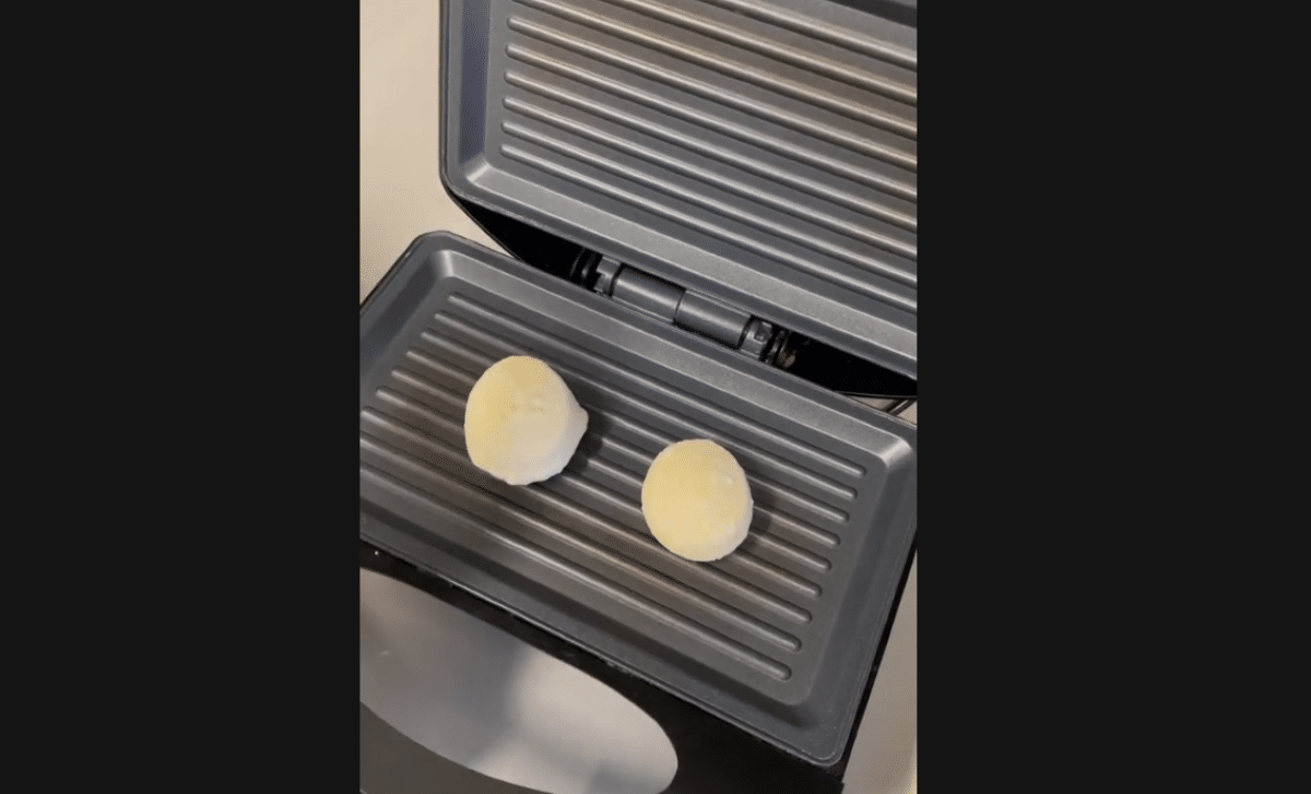 Pão de queijo na sanduicheira: etapa inicial da receita na sanduicheira, mostrando o queijo ainda não derretido.