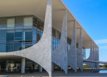 Fachada do Palácio do Planalto em Brasília, sede do governo federal, sob um céu azul, representando as decisões governamentais sobre o Bolsa Família.