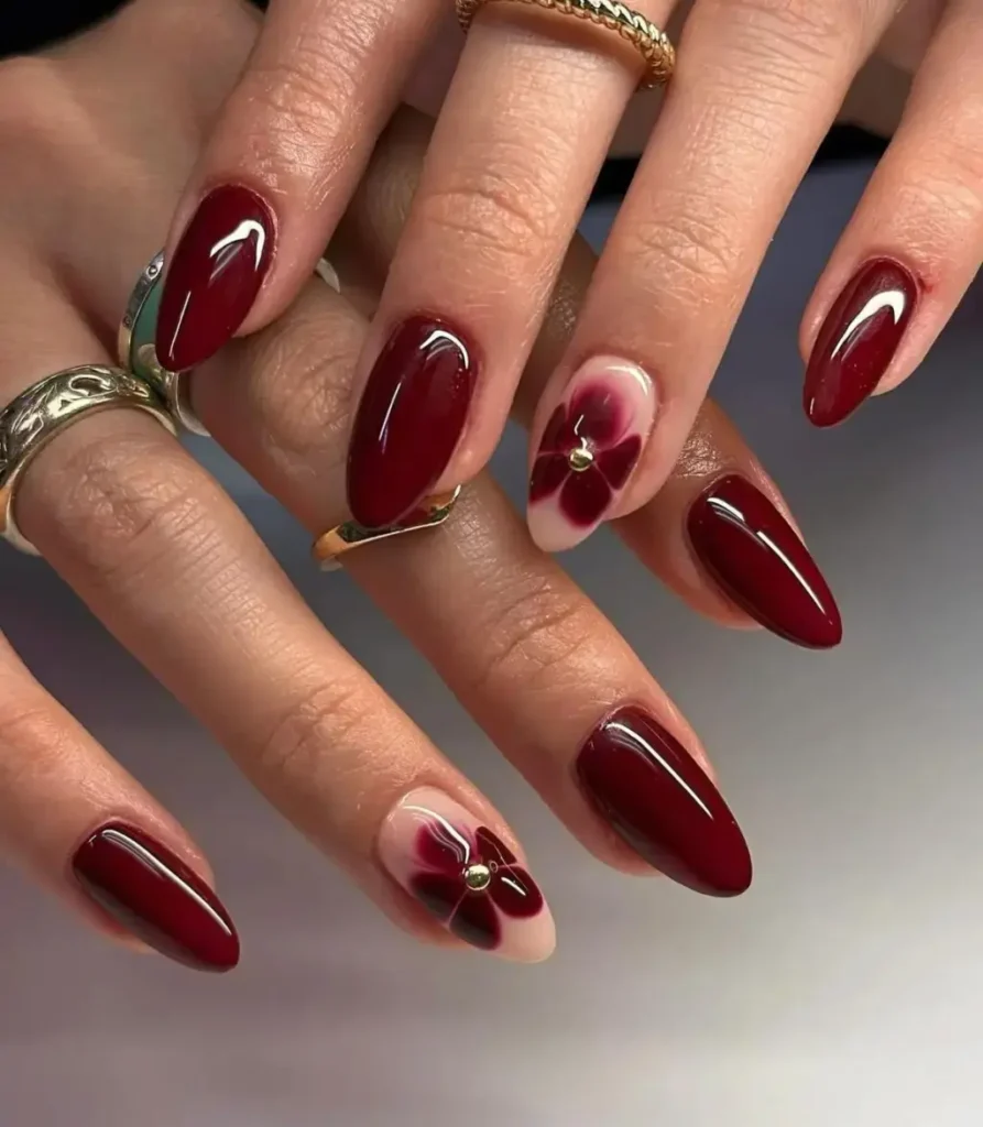 Unhas com esmaltação bordô e decoração floral na filha única, estilo sofisticado e elegante.