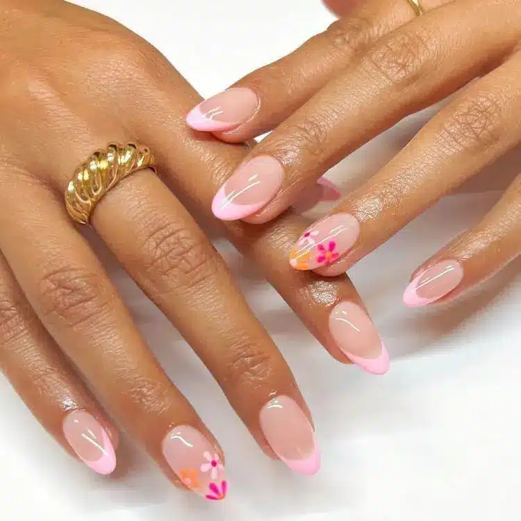 Unhas com esmalte nude e filha única decorada com flor delicada.