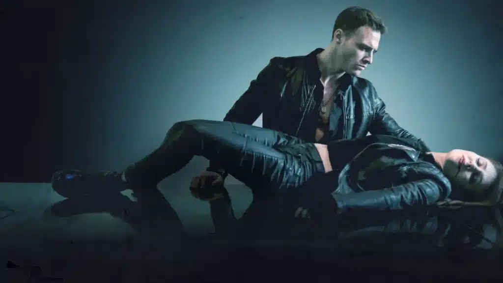 Cena dramática de Immortals, mostrando Mia e Dmitry em um momento de tensão.