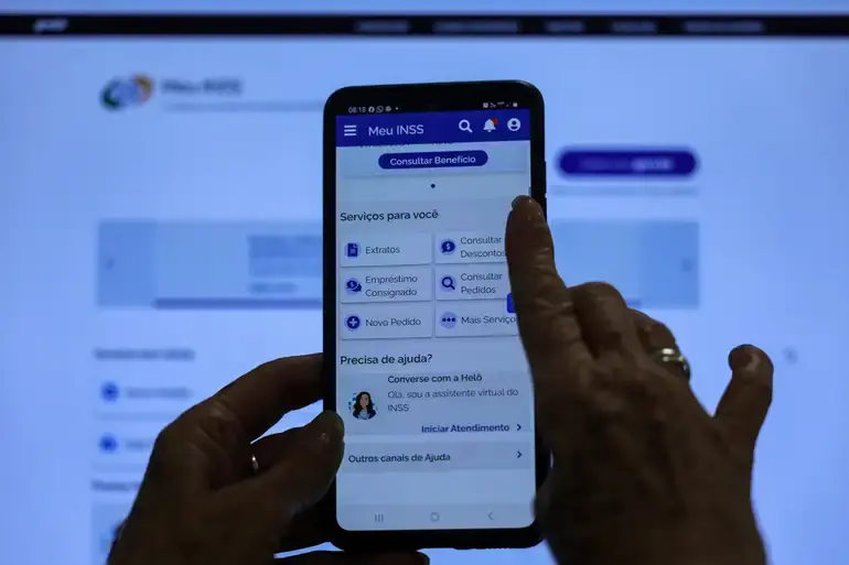 Pessoa acessando o aplicativo Meu INSS no celular para consultar benefícios e serviços disponíveis.