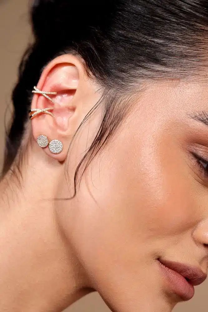 Imagem de close-up de orelha com múltiplos piercings, incluindo solitários de diamante e piercings delicados, ideal para noivas modernas.