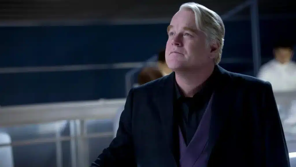 Philip Seymour Hoffman como Plutarch Heavensbee em Jogos Vorazes: A Esperança – Parte 1, uma cena de seu último trabalho antes de sua morte.