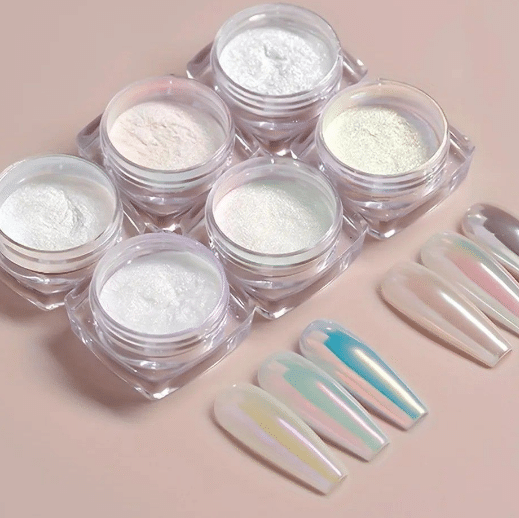 Potes de pó para unhas com efeito iridescente e quatro unhas decoradas com cores peroladas e cintilantes.