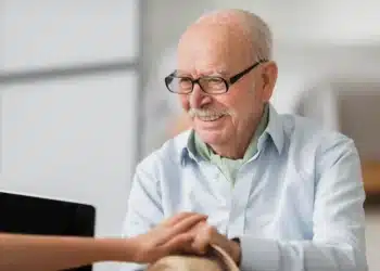 Idoso sorridente recebendo apoio e orientação financeira.