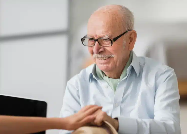 Idoso sorridente recebendo apoio e orientação financeira.