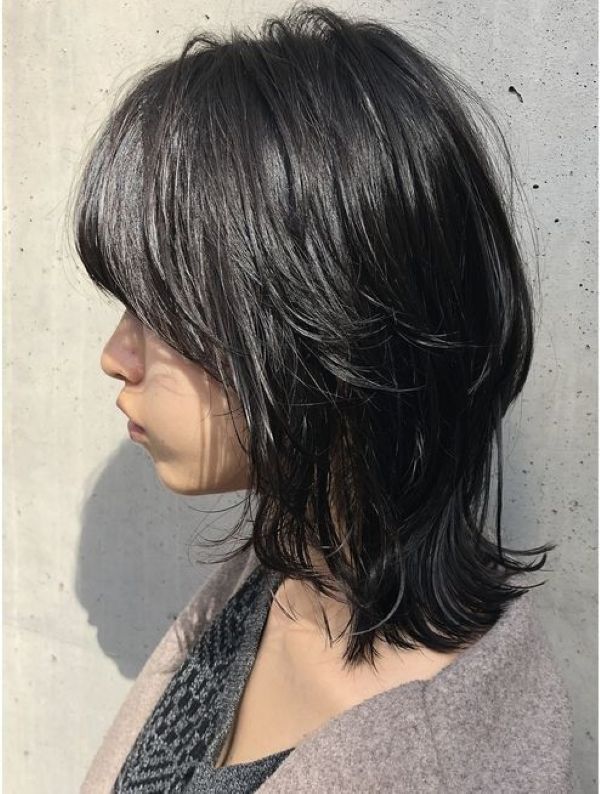 Mulher com o corte de cabelo curto e repicado estilo Wolf Cut, com franja, ideal para rejuvenescer mulheres 50+ com um visual moderno e despojado.