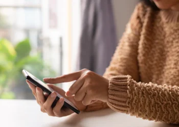 Imagem de uma pessoa usando o celular para interagir com amigos e familiares.