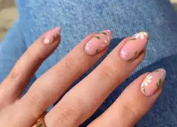 Unhas decoradas com flores delicadas em tom rosa, tendência leve para a primavera.