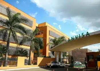 Fachada da sede da Anvisa, com um grande letreiro verde 'ANVISA' na entrada.