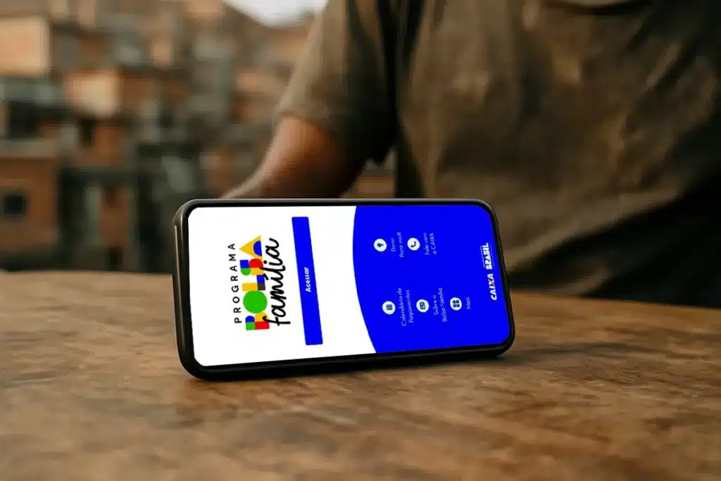 Aplicativo do Programa Bolsa Família exibido em celular sobre mesa, representando o acesso digital ao benefício.