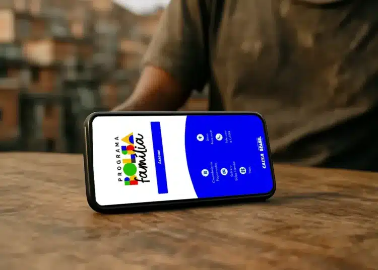 Aplicativo do Programa Bolsa Família exibido em celular sobre mesa, representando o acesso digital ao benefício.