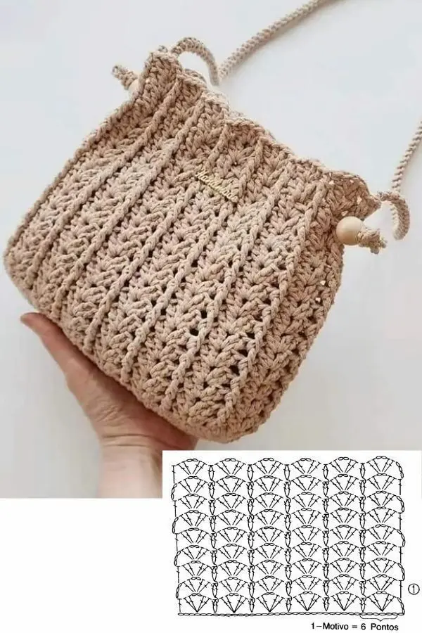 Bolsa transversal de crochê bege com alça longa e textura em pontos abertos.