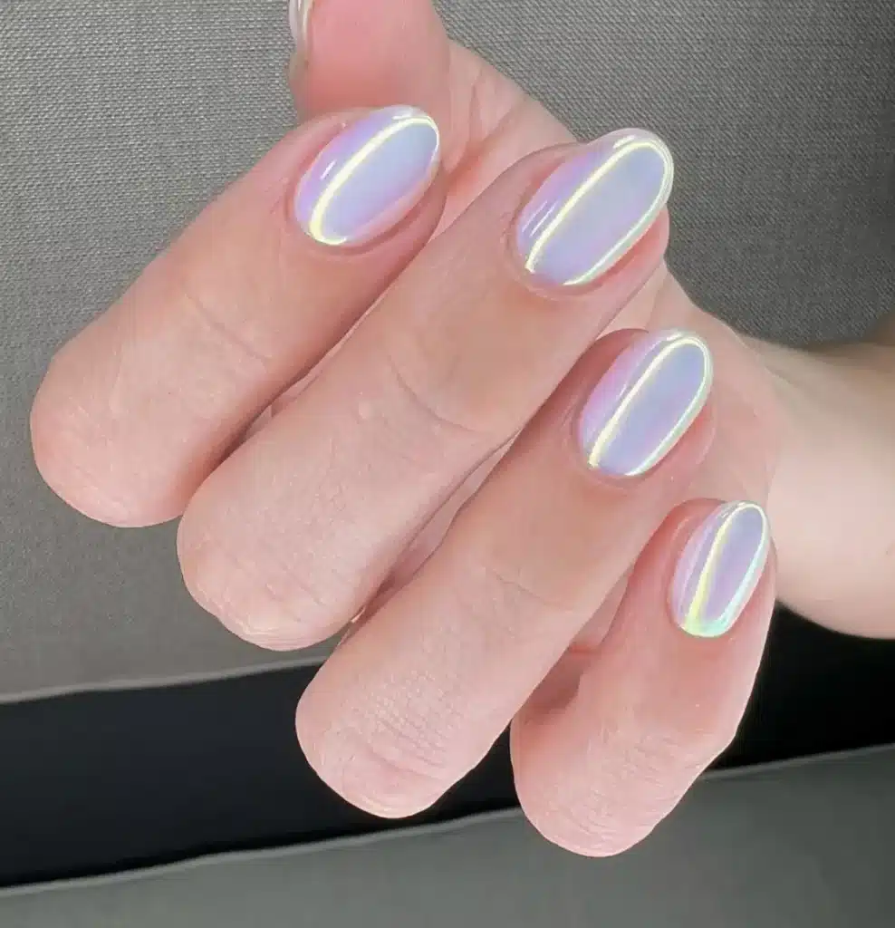 Unhas curtas com esmalte holográfico em tom perolado e brilho iridescente.