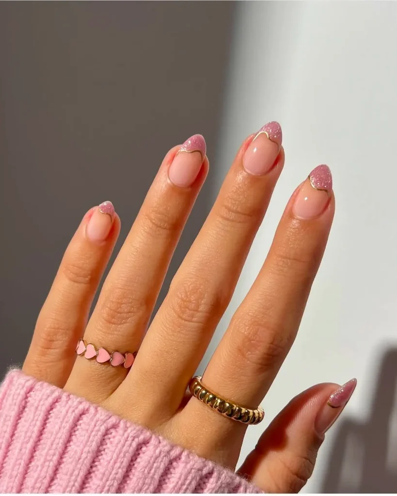 Unhas com francesinha moderna em rosa com glitter e contorno dourado.