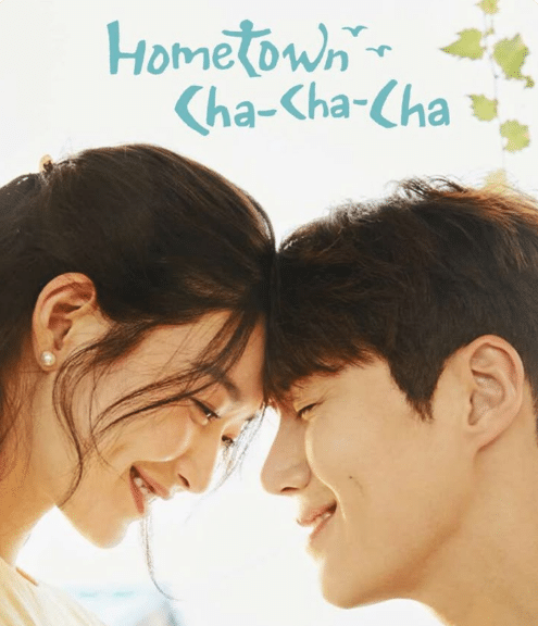 Casal asiático sorrindo com a testa encostada em um fundo claro com texto Hometown Cha-Cha-Cha