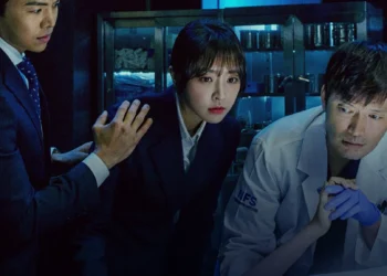 Médico legista e promotora investigando juntos em uma cena forense tensa.