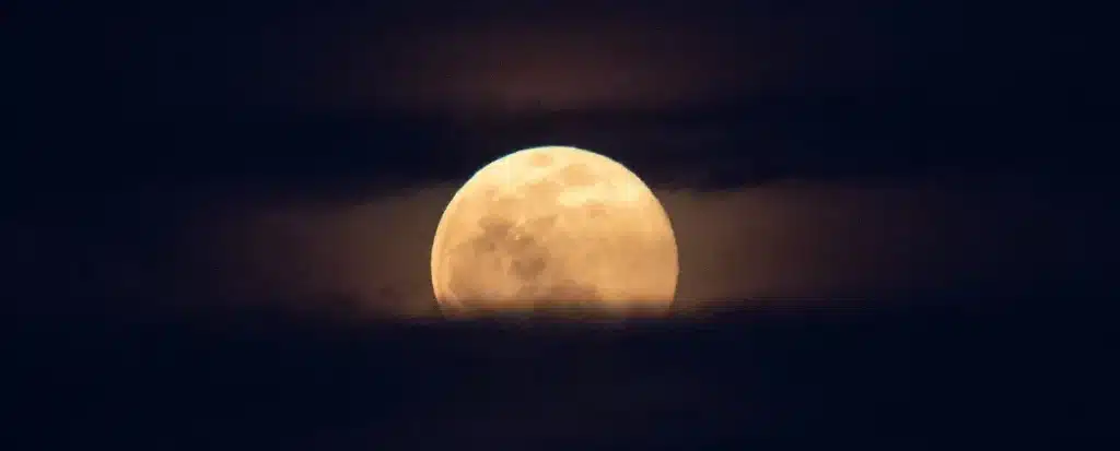 Superlua vista por entre nuvens noturnas.