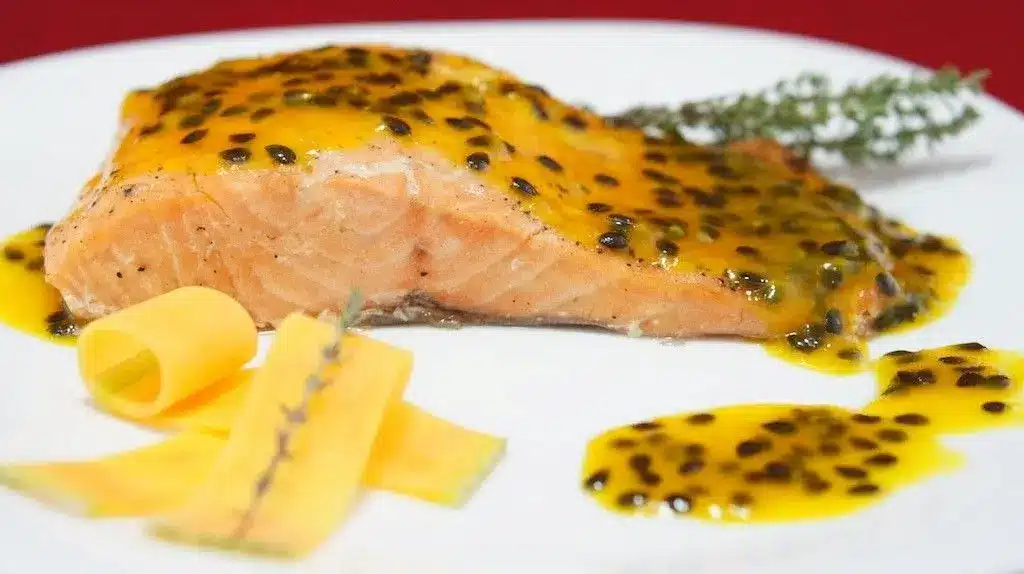 Salmão grelhado coberto com molho de maracujá.