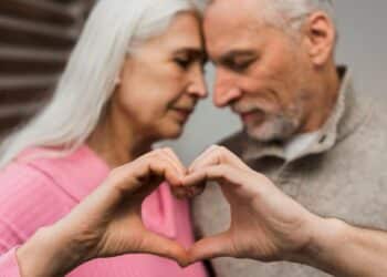 Casal idoso demonstrando carinho e formando um coração com as mãos