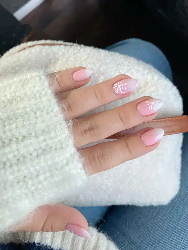 Unhas com Flocos de Neve Delicados para o Natal Unhas decoradas com flocos de neve delicados sobre uma base clara e translúcida.
