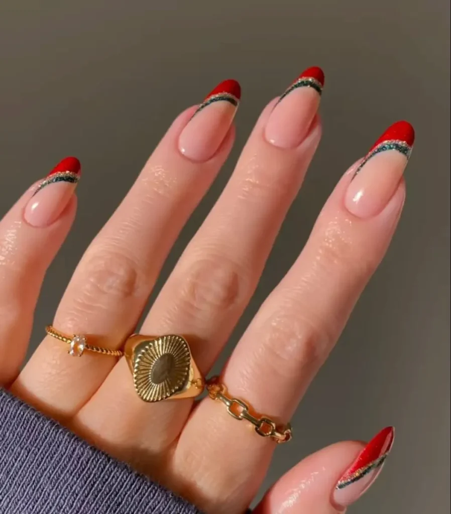 Francesinha natalina Unhas com francesinha natalina vermelha, decoradas com linhas douradas e de glitter.