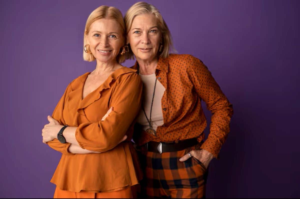 Duas mulheres maduras e estilosas, vestindo tons terrosos harmoniosos, demonstrando o uso estratégico de cores na coloração pessoal para realçar a beleza.