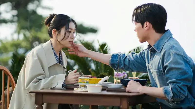 Cena de “Beijo Explosivo” com Ji-hyeok oferecendo comida a Go Da-rim durante um momento íntimo ao ar livre.