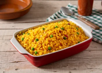 Arroz amarelo com ervilhas frescas, perfeito para servir como acompanhamento em um almoço de fim de semana.