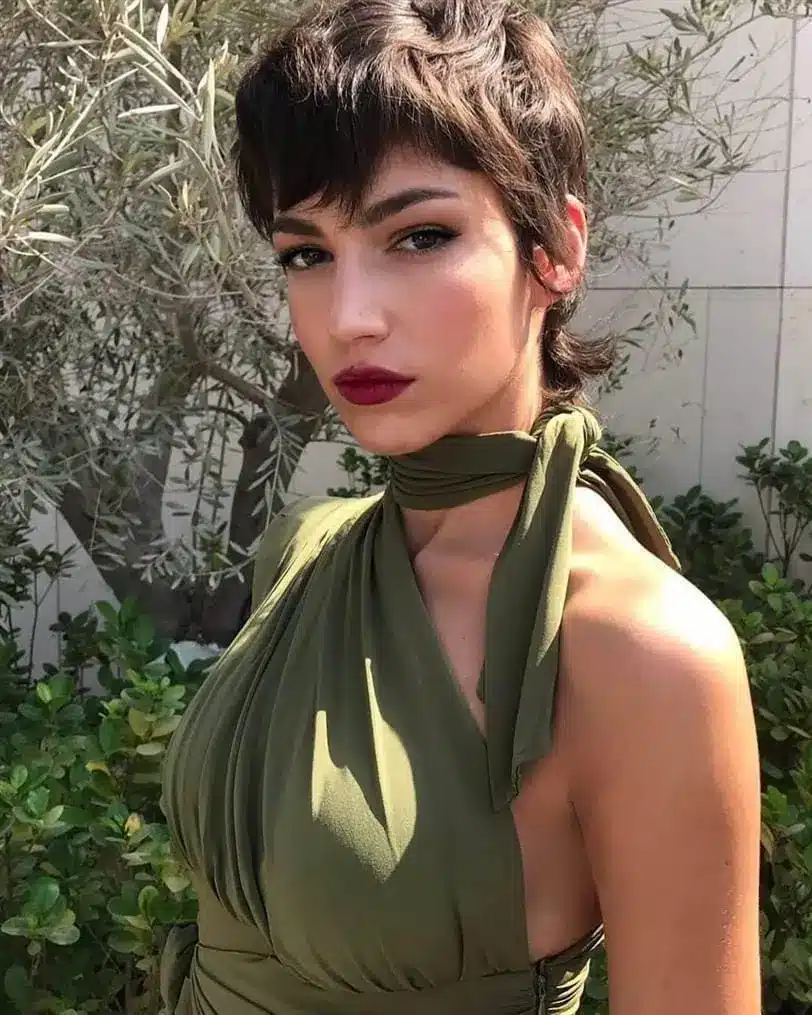 Mulher com corte mullet moderno posando ao ar livre.