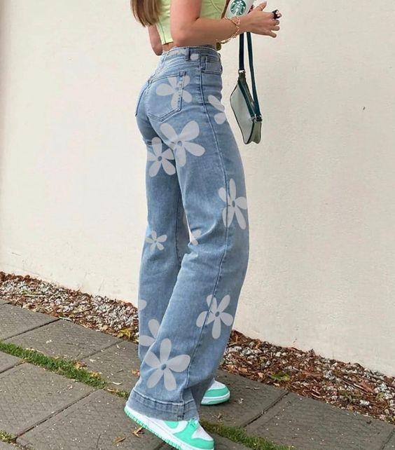 Calça jeans reta clara com estampa de flores brancas (Tendência jeans estampados anos 70/boêmio)