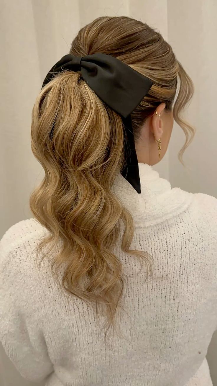 Modelo sorridente usando vestido de festa vermelho ao lado de uma árvore de Natal decorada. A imagem sugere inspiração para o look completo de festa, incluindo o penteado simples e elegante como o rabo de cavalo repaginado.