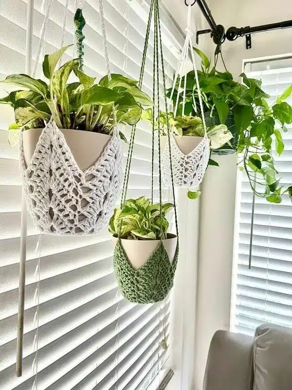 Suporte de vaso em crochê, hangers modernos, com plantas penduradas em um ambiente iluminado por luz natural.