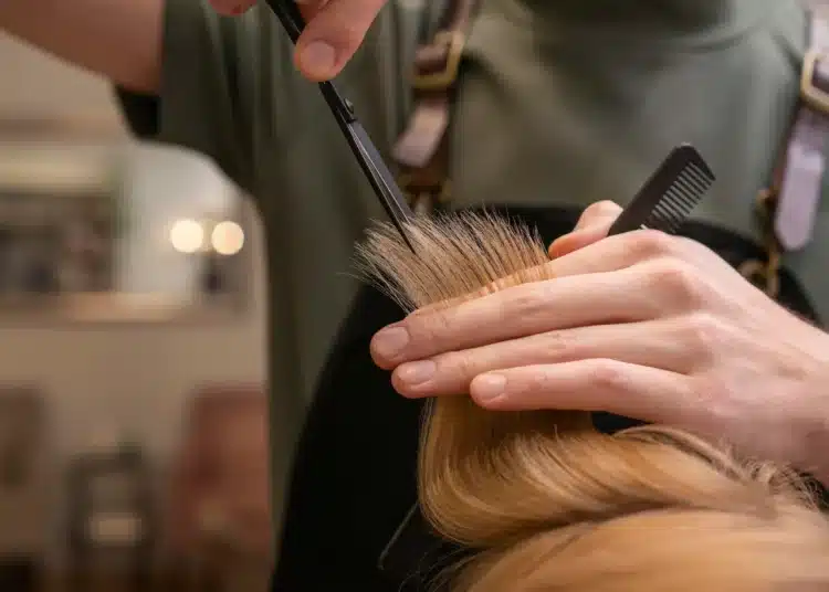 Profissional cortando mechas de cabelo em salão de beleza como ilustração para cortes de cabelo modernos para 2026.