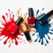 Frascos de esmaltes coloridos com respingos vibrantes em vermelho, azul e dourado.