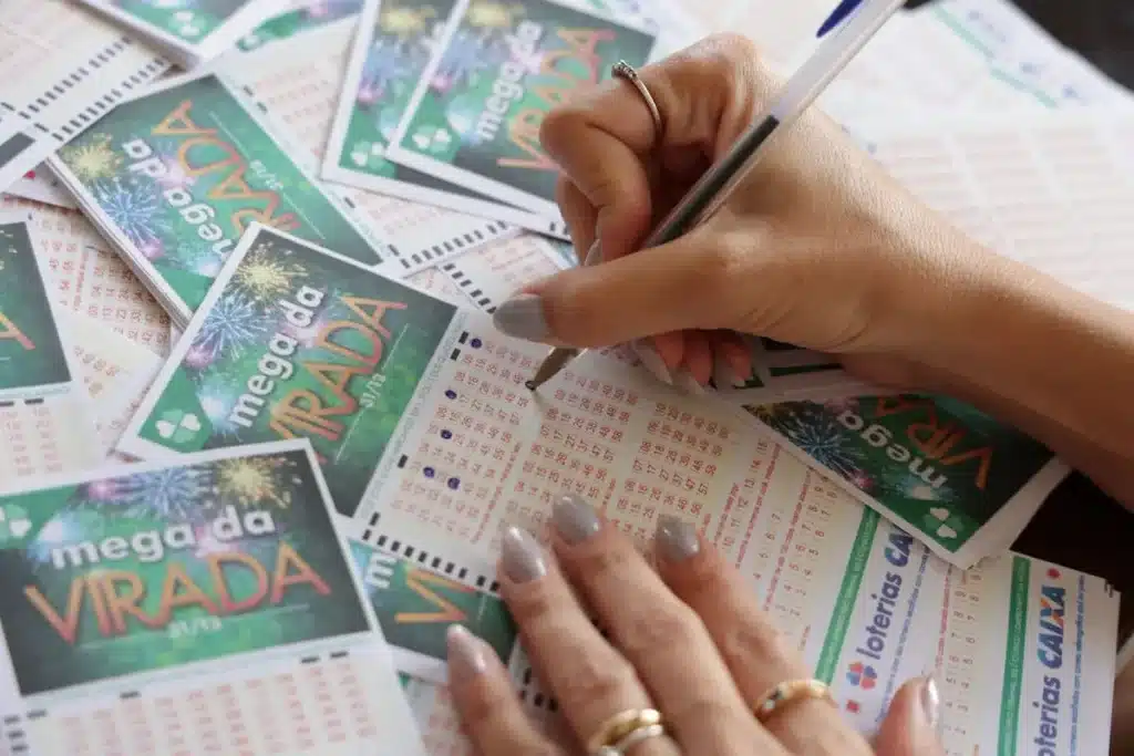 Pessoa marcando números do bilhete da Mega da Virada nas últimas horas antes do sorteio milionário.