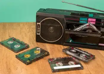 Rádio retrô com fitas cassete, representando o ambiente musical da década de 80, época das músicas mais tocadas.