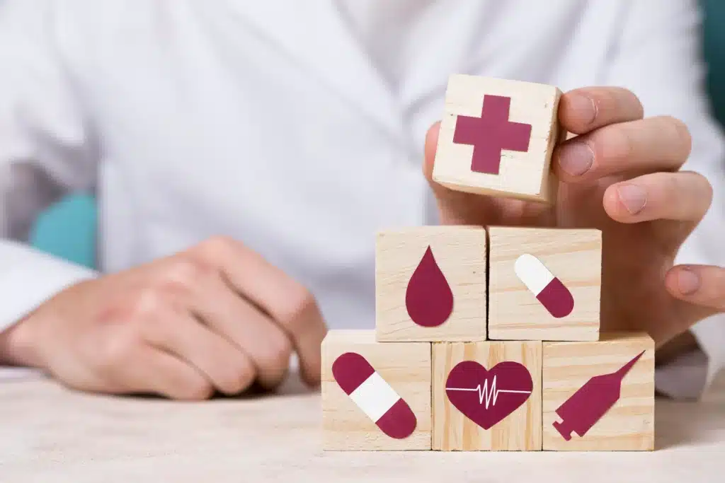 Profissional de saúde organizando blocos com símbolos médicos, representando a proteção contra aumentos abusivos e a importância de conhecer seus direitos no plano de saúde.